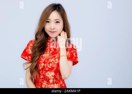 Beautiful portrait happy Chinese New Year young asian woman wear cheongsam smile with gesture congratulation and greeting isolated on white background Stock Photo