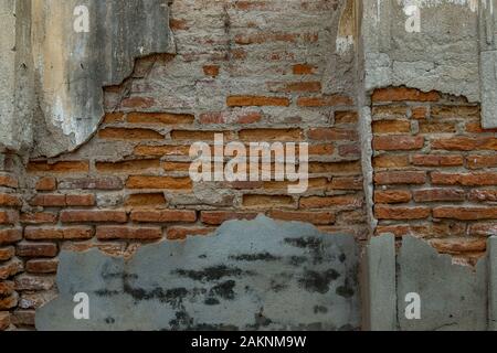 Background texture from old red brick wall with cracked plaster, Old wall rupture brick texture background, Weathered brick wall, Copy Space. Stock Photo