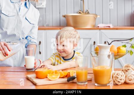 Mother And Son Are Smiling While Having A Breakfast In Kitchen. Mom Is  Pouring Milk Into Glass Stock Photo, Picture and Royalty Free Image. Image  83212891.