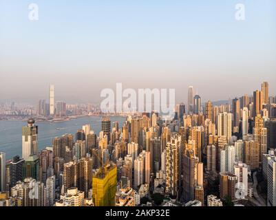 Aerial view of the sunset over the very crowded residential of Kennedy town and Sai Yin Pun in Hong Kong island with Kowloon in the background across Stock Photo