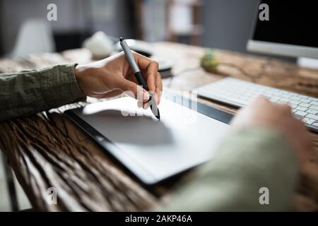 Close-up Of A Businessman Using Graphic Tablet In Office Stock Photo