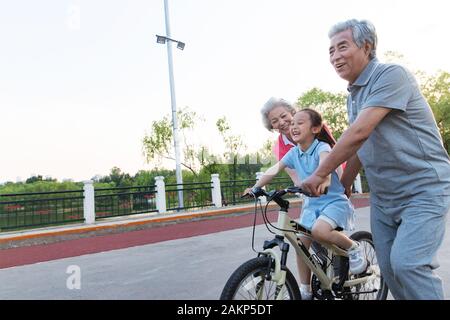 Older couples with a granddaughter to ride a bicycle Stock Photo