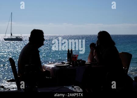 Silhouette of senior couple sitting in a restaurant near Jandia Playa beach , Morro Jable, Jandia Peninsula, Fuerteventura, Canary Islands, Spain,Euro Stock Photo