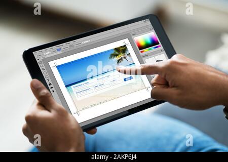 Human Hand Holding Digital Tablet In Office Stock Photo