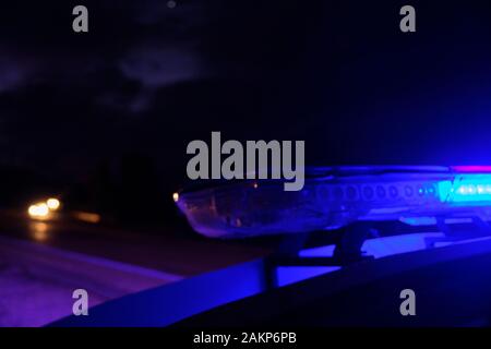 police car flashing lights in the night selective focus. Stock Photo
