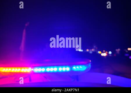 police car flashing lights in the night blurred selective focus. Stock Photo