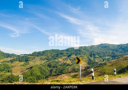 yellow right curve sign on mountain Stock Photo