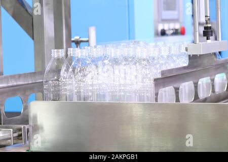 a group of platic bottles in production line wait to fill water . engineering equipment indutrial background Stock Photo