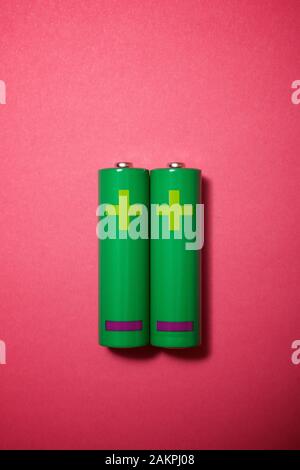 Two small batteries on a pink table. Stock Photo