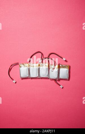 Drone batteries on a pink table. Stock Photo