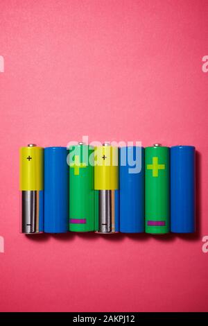 Small batteries on a pink table. Stock Photo