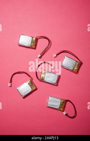 Drone batteries on a pink table. Stock Photo