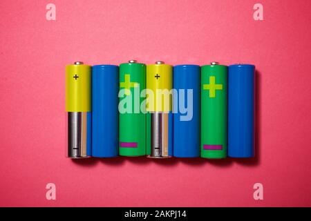 Small batteries on a pink table. Stock Photo