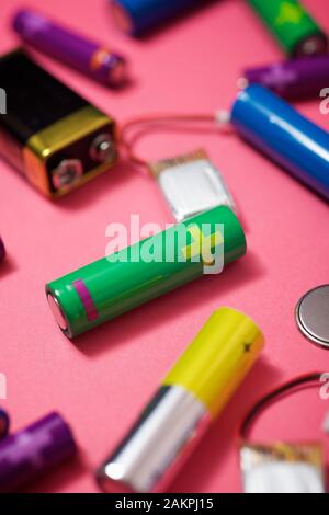 Many batteries on a pink table. Stock Photo