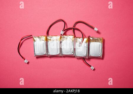 Drone batteries on a pink table. Stock Photo