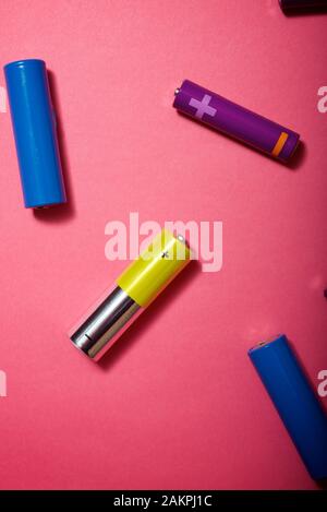 Many batteries on a pink table. Stock Photo
