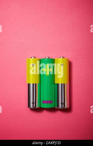 Small batteries on a pink table. Stock Photo