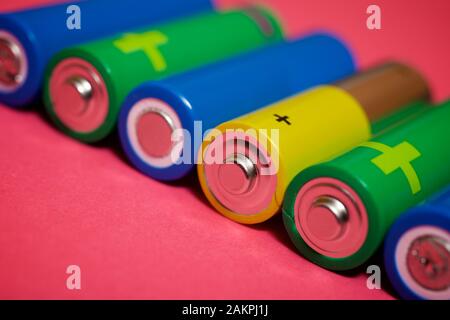 Small batteries on a pink table. Stock Photo