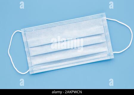 Surgical mask with rubber ear straps. Typical 3-ply surgical mask to cover the mouth and nose. Procedure mask from bacteria. Protection concept Stock Photo