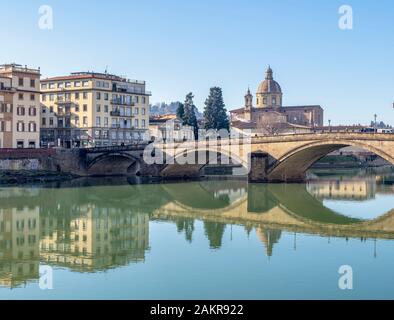 FLORENCE, ITALY, January 6, 2020: The River Arno in winter sunshine. Ponte Santa Trninita bridge looking to San Frediano in Cestello church in the Stock Photo