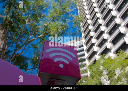 Brisbane, Queensland, Australia - 7th November 2019 : Purple colored WiFi sign of the Telstra company installed on the top of a phone booth in the cit Stock Photo