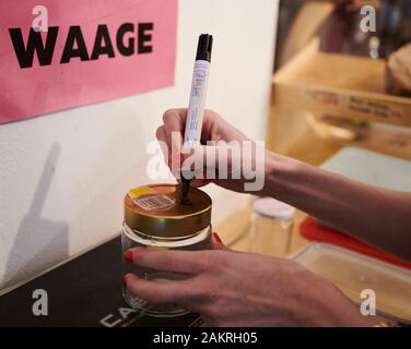 Berlin, Germany. 07th Jan, 2020. A customer writes the number of grams of the empty glass on the lid with a marker pen. In the unpackaged store, the containers brought in are first weighed, then filled, weighed again and the difference paid. Credit: Annette Riedl/dpa-Zentralbild/ZB/dpa/Alamy Live News Stock Photo