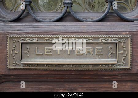 View of an old mail box integrated in a wooden door with the inscription 'Lettere' (means letters). Captured in a typical italian village on the lake Stock Photo