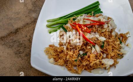 Asian eating food, Mee Grob is an sweet and sour crispy noodles, made from Thai rice noodle with sweet and sour sauce on white plate, Sweet & Sour Cri Stock Photo