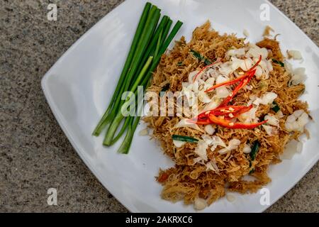 Asian eating food, Mee Grob is an sweet and sour crispy noodles, made from Thai rice noodle with sweet and sour sauce on white plate, Sweet & Sour Cri Stock Photo
