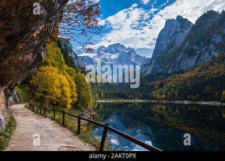 Sunny idyllic colorful autumn alpine view. Peaceful mountain lake with clear transparent water and reflections. Gosauseen or Vorderer Gosausee lake, U Stock Photo