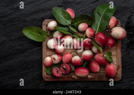 Bengal-Currants, Carandas-plum or Karonda fruit (Carissa carandas L.) sour taste fruit on wicker. Top view. Stock Photo