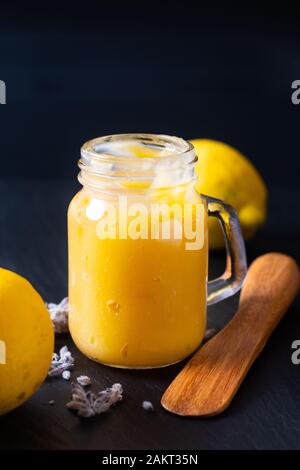 Food idea concept homemade lemon curd in glass jar on black background Stock Photo