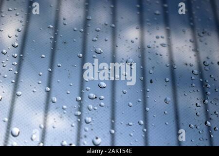 Raindrops on a glass door with mesh curtain Stock Photo