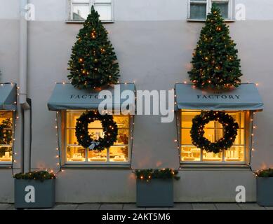 VILNIUS, LITHUANIA - DECEMBER 29, 2019: Christmas light installation an illumination  on fir trees on the Factory brand shop. Here sell exclusive deco Stock Photo