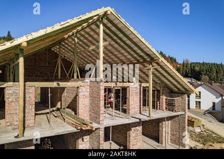 Wooden frame of new roof on a brick big house under construction. Stock Photo