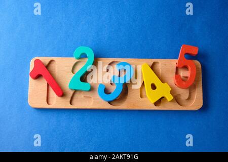 Multi colored toy numbers at blue background with copy space. Stock Photo