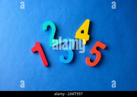 Multi colored toy numbers at blue background with copy space. Stock Photo