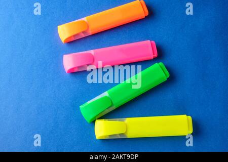 Multi colored highlighters at blue background with copy space. Stock Photo