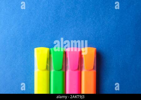 Multi colored highlighters at blue background with copy space. Stock Photo