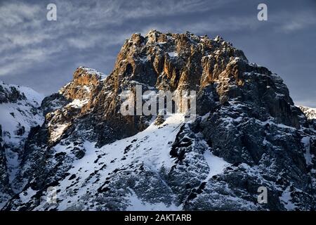 Sunrise at high mountains with snow against blue sky at winter time in Kazakhstan