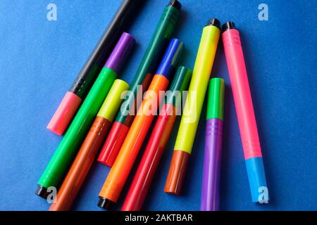 Multi colored felt pens with wrong color caps at blue background. Stock Photo
