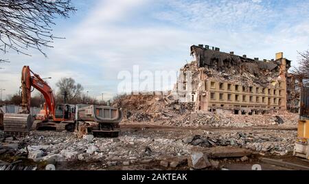 Kraków, Poland - December 17, 2019: Demolition of an old office building, called Elbud in a traditional way, using excavators, bulldozers and other de Stock Photo