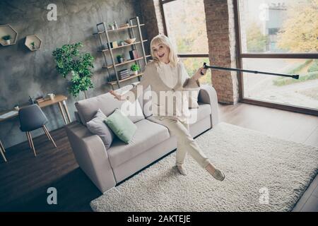 Full length body size view of nice attractive healthy cheery glad funky cheerful gray-haired grandma dancing with cane having fun time lifestyle at Stock Photo