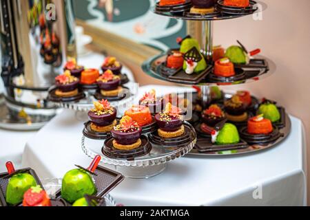 Different sort of beautiful pastry, small colorful sweet cakes. Stock Photo