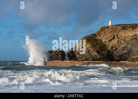 Stormy weather at Portreath, Cornwall, UK with waves breaking over the Monkey Hut which was originally built as a shelter for the harbour pilots. Stock Photo