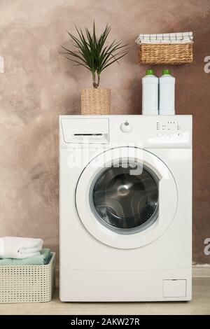 Laundry room with washing machine against brown wall Stock Photo