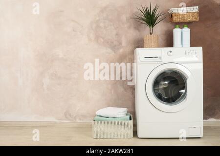 Laundry room with washing machine against brown wall Stock Photo
