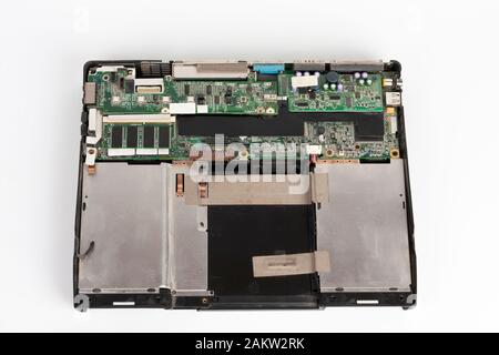 Old laptop, removed monitor , keyboard, touchpad, battery, upper cover  and  floppy disk drive on white background. Stock Photo