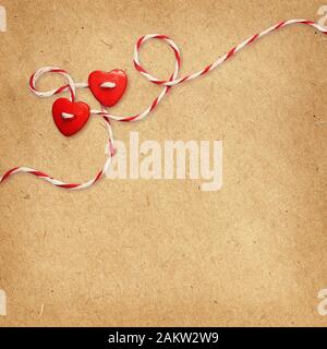 Two hearts tied with rope on craft paper background for Valentine's Day Stock Photo