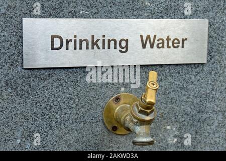 Drinking water metal plaque with tap underneath on quartz wall, close up. Taken at Inversnaid, Loch Lomond, on route of West Highland Way. Stock Photo